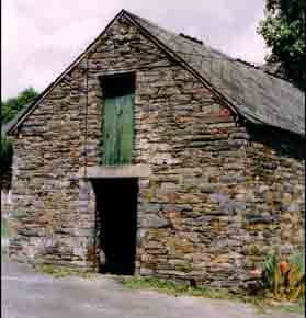 Cette tr&egrave;s belle remise de la Bou&egrave;re a des murs en moellons de schiste, le toit &agrave; deux pentes est en ardoises. A remarquer que les ouvertures, au nombre de sept, sont curieusement dispos&eacute;es :la porte et la gerbi&egrave;re, celle-ci avec un linteau en bois ( photo ci-contre) sont plac&eacute;es sur le pignon orient&eacute; Ouest ; sur la fa&ccedil;ade Sud, il y a une porte et enfin la fa&ccedil;ade Nord est perc&eacute;e d&rsquo;une porte, d&rsquo;une lucarne et de deux fenestrelles obstru&eacute;es par des briques. Cette remise devait servir de cave et de resserre pour les r&eacute;coltes, de pommes de terre en particulier ; le grenier, quant &agrave; lui, servait certainement &agrave; remiser le foin